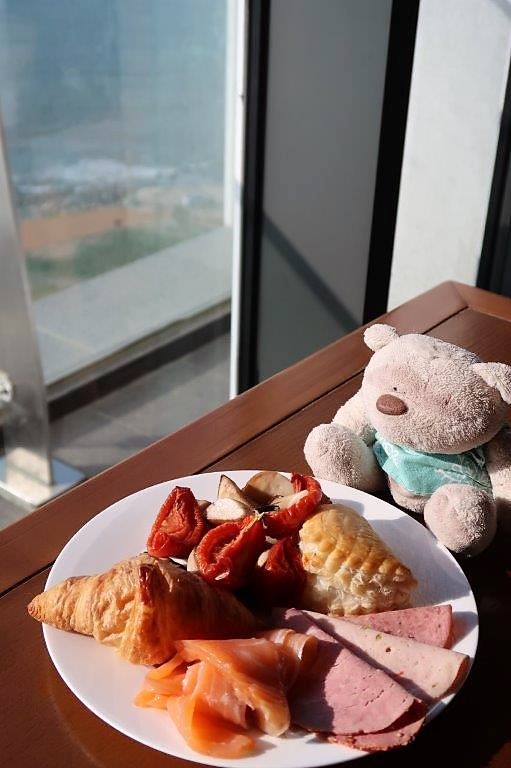Tom having breakfast while enjoying the sunrise and sea views