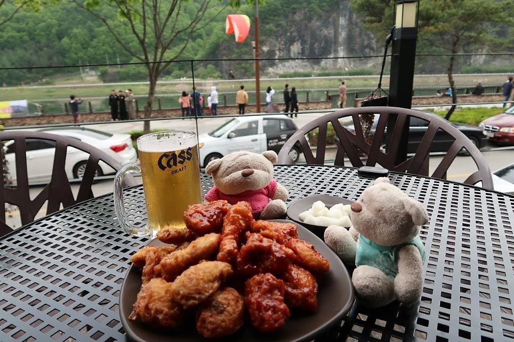 Enjoying Kyochon Chicken as Paragliders landed with Yongbaek falls in the background