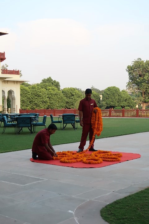 Staff setting up the Rangoli in front of the Verandah Cafe at Rambagh Palace Jaipur