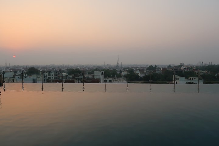 Sunset with Taj Mahal in the distance as seen from Hotel Radisson Blu Agra Taj's Rooftop Infinity Pool
