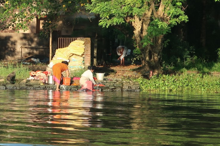 Villagers going about their daily activities along the banks of Kerala backwater alleyways