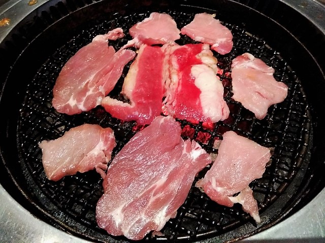 Assorted meats over hot charcoal grill at Rocku Yakiniku