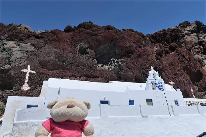 Red rock formations with a Greek church at Red Beach Santorini